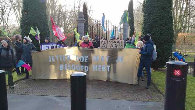 A group of rebels at Huis ten Bosch Palace during the swearing-in of the Jetten cabinet. The rebels carry flags with XR symbols and hold up a banner with the text “Jetten, do what you promised”.